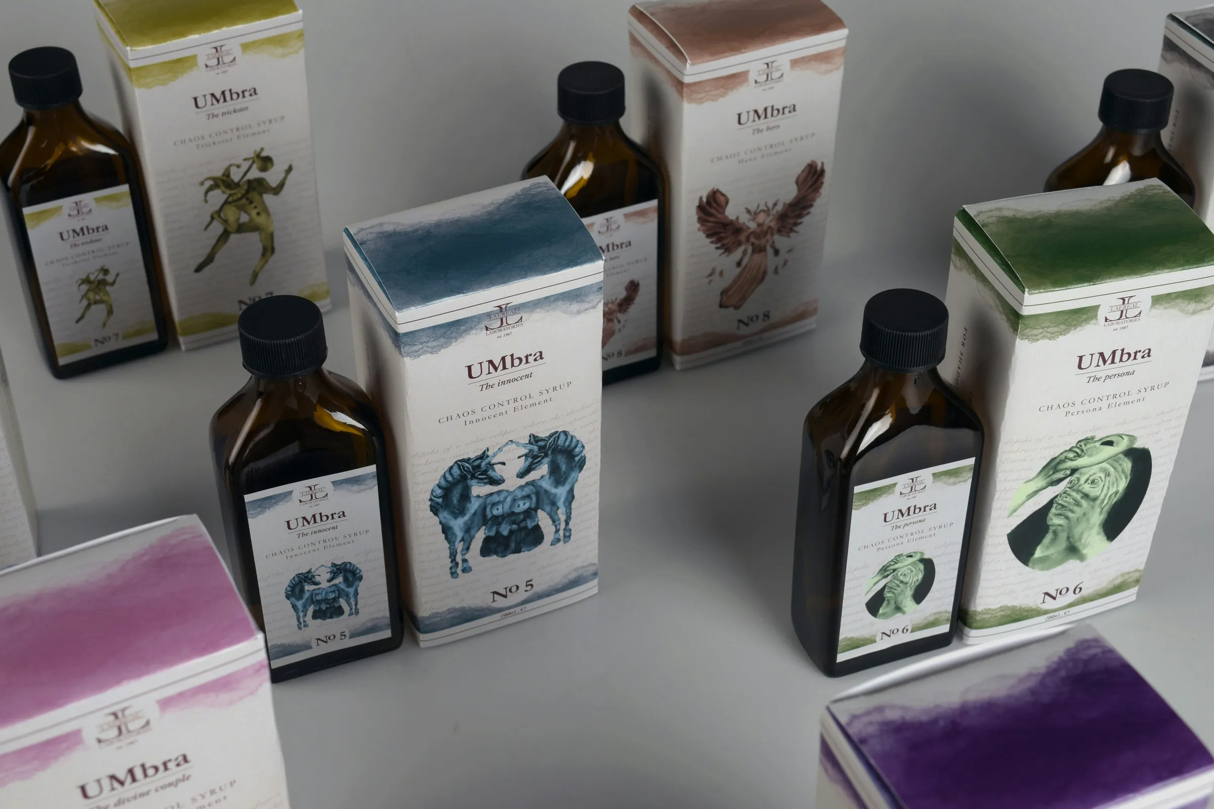 Amber glass bottles with illustrated labels beside matching watercolour-print cartons