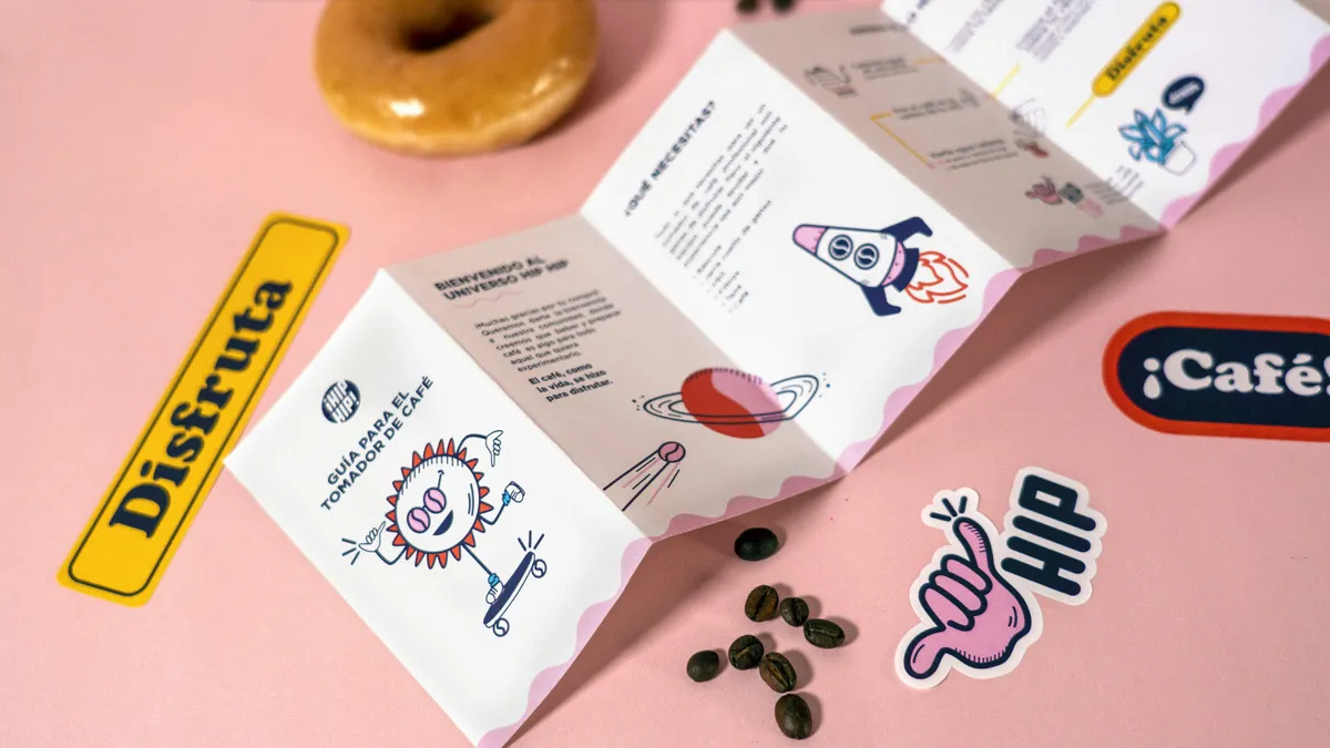 Illustrated folded brochure and brand stickers on a pink background