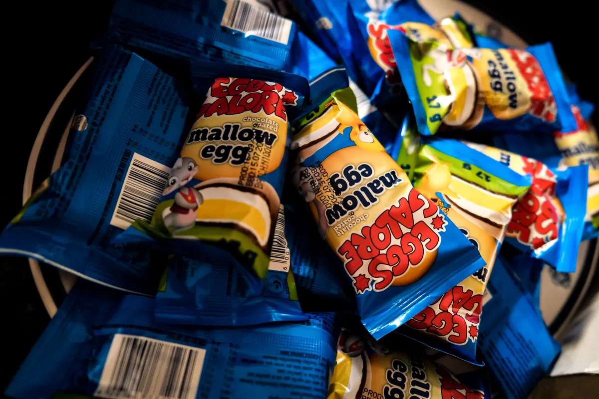 Pile of brightly printed foil sweet wrappers in blue, yellow and red