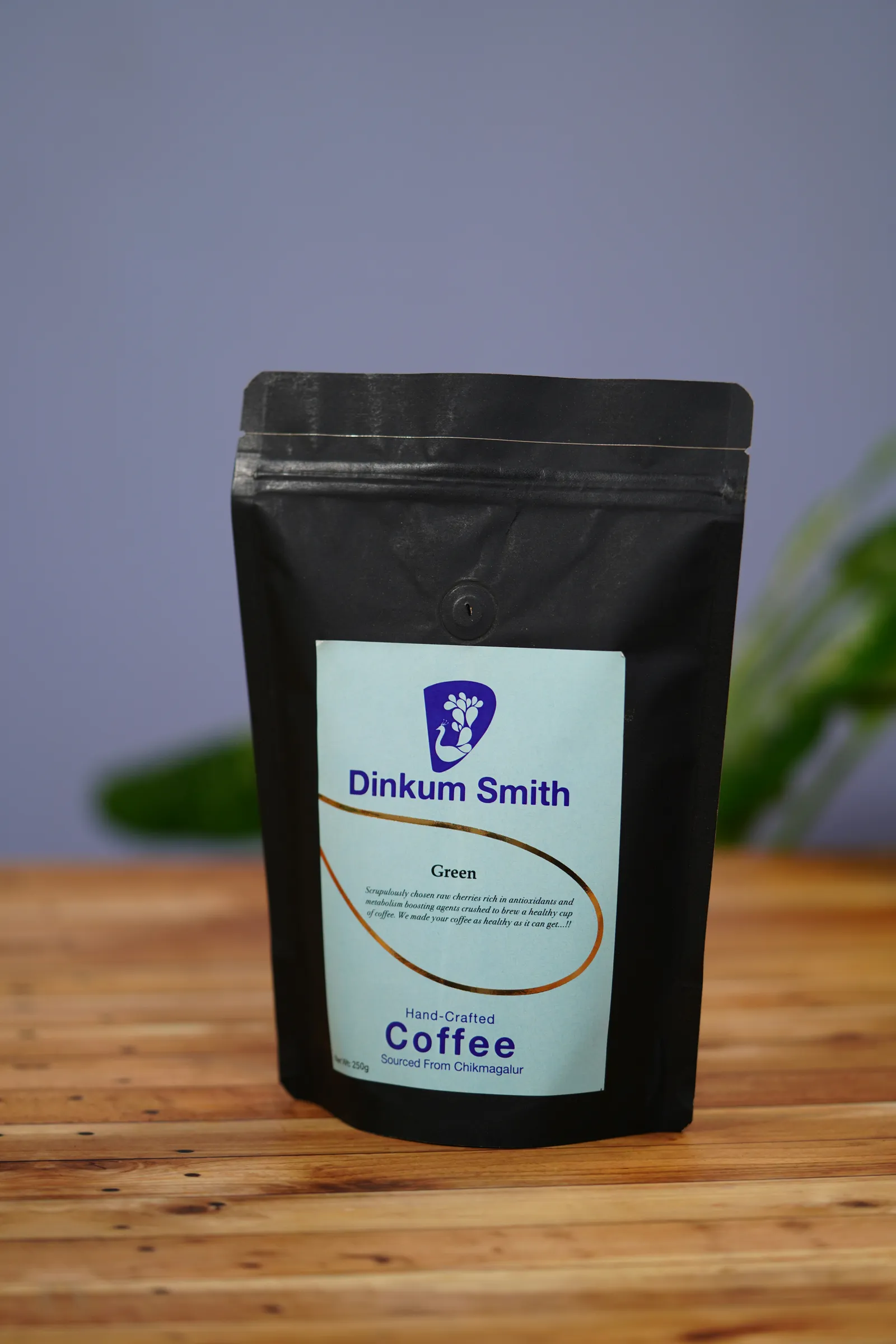 Black stand-up coffee pouch with a printed front label on a wooden table