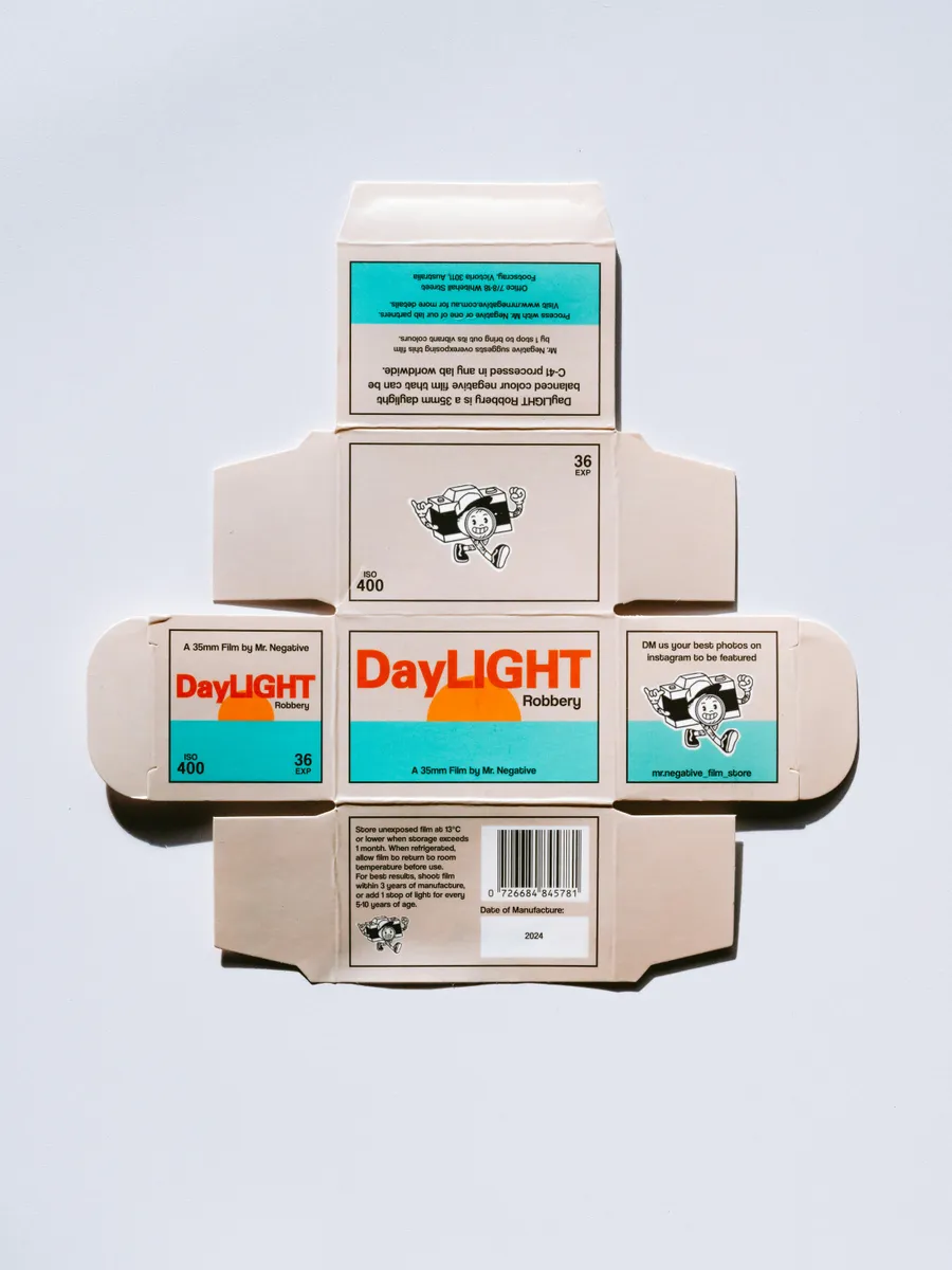 Flat printed film box carton laid out on its dieline, with turquoise and orange artwork