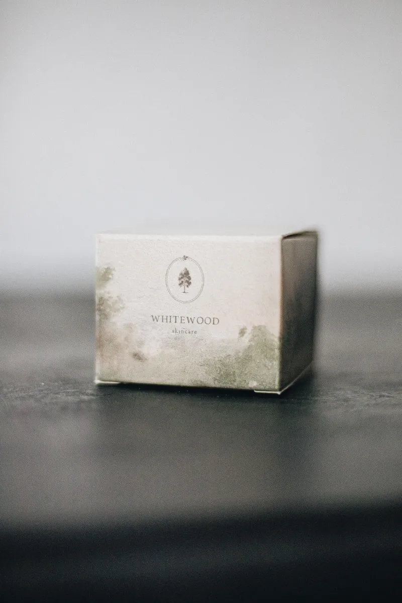 Minimal white candle carton with a soft green print