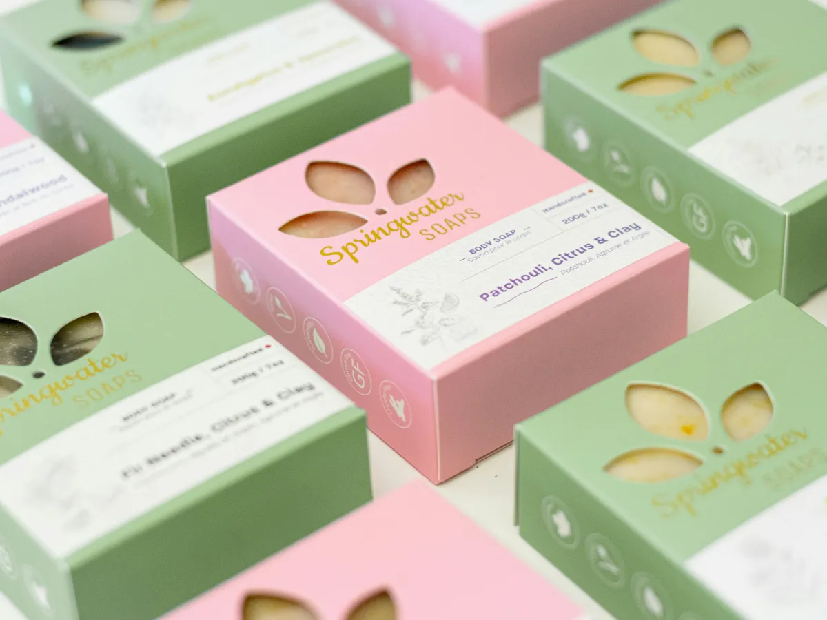 Pink and green soap folding cartons with leaf-shaped die-cut windows showing the bars inside