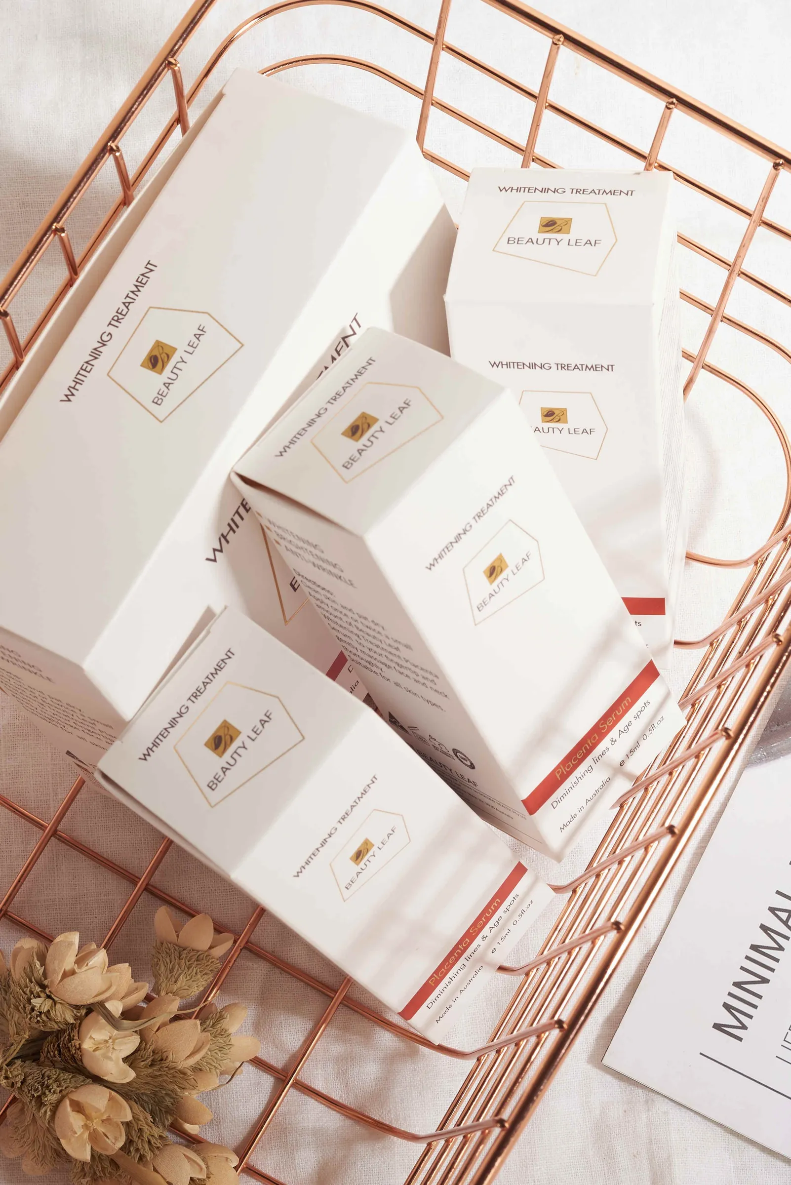 White skincare cartons in a copper wire basket