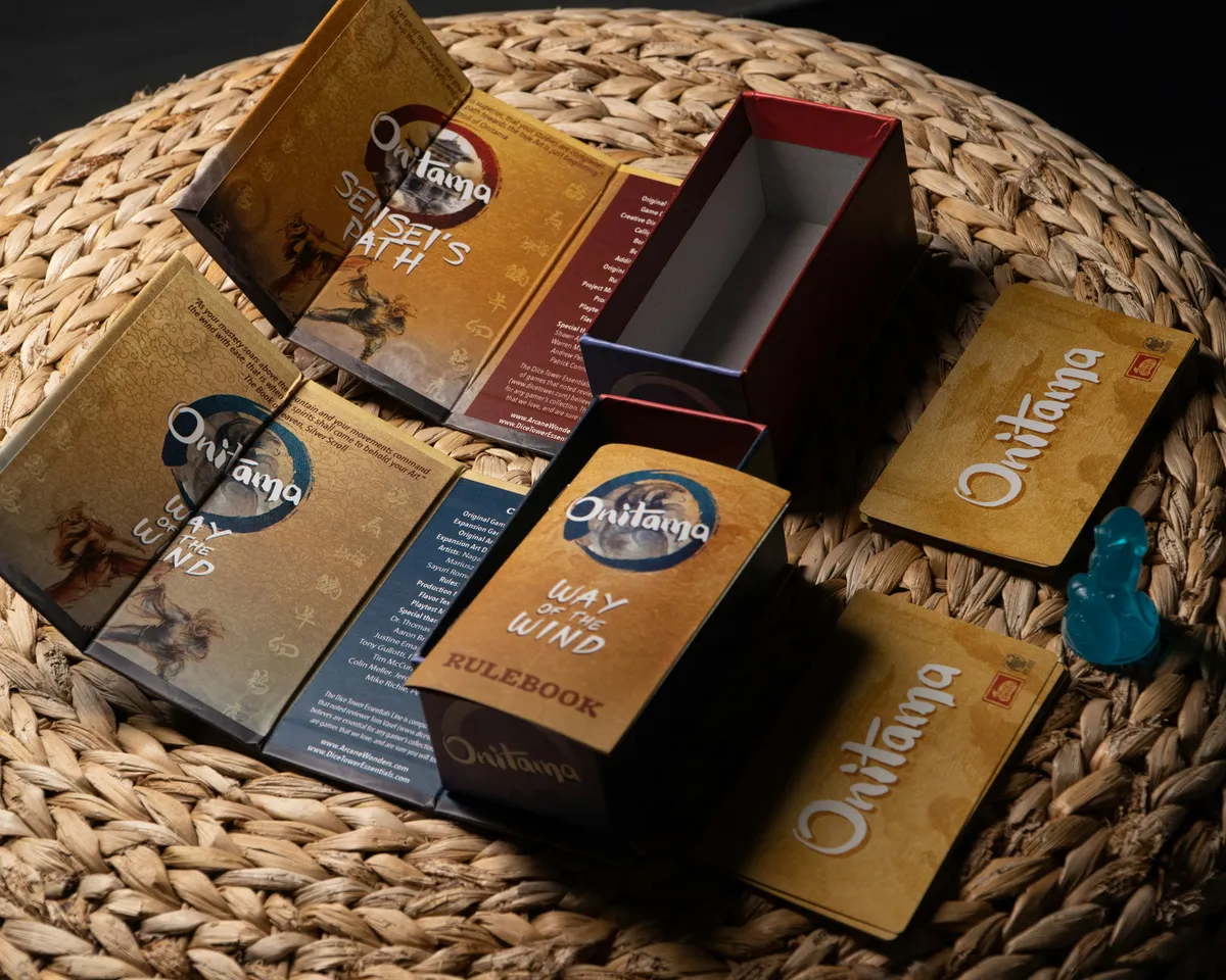 Illustrated board game boxes with a rulebook and cards